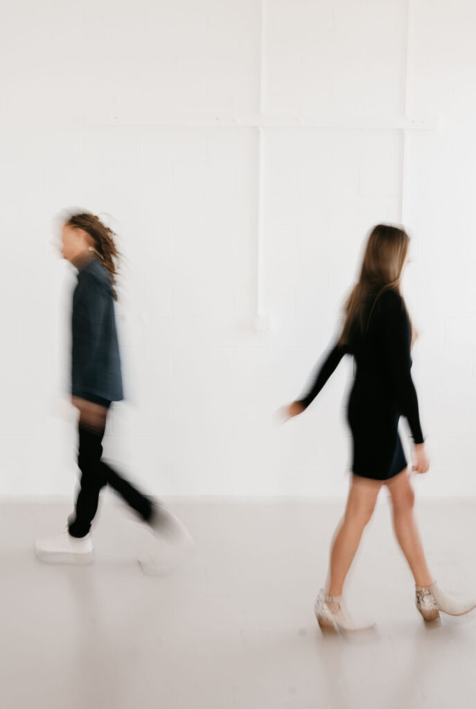 Mn Couple walking away form eachother, white background, blurry