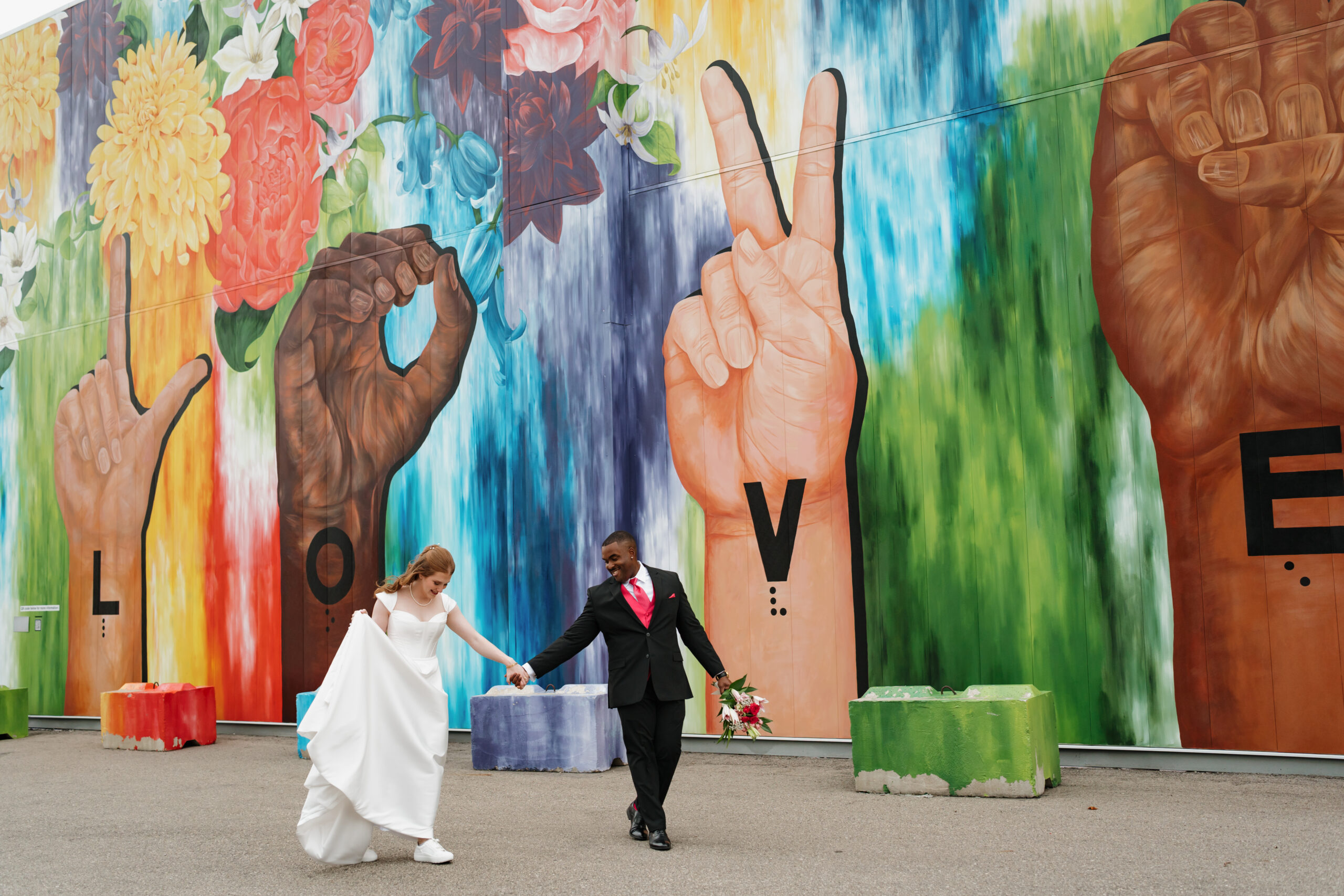 Bride and groom in front of mural