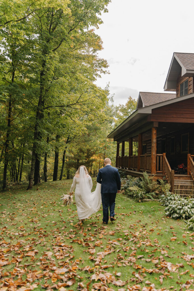 Bride and groom walking to log cabin