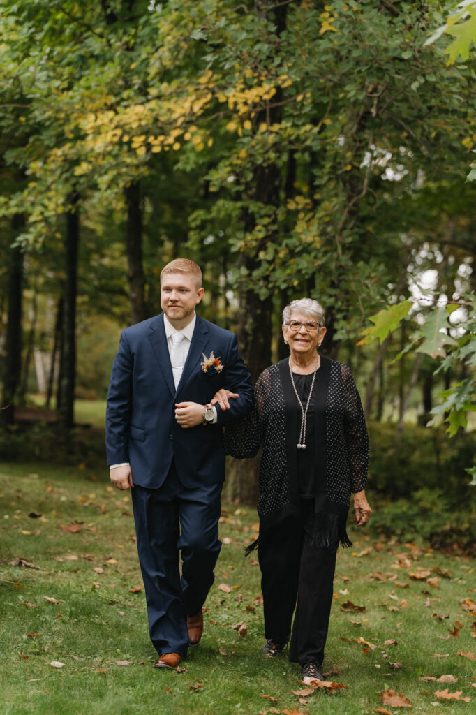 Groom adn grand mother walking down aisle
