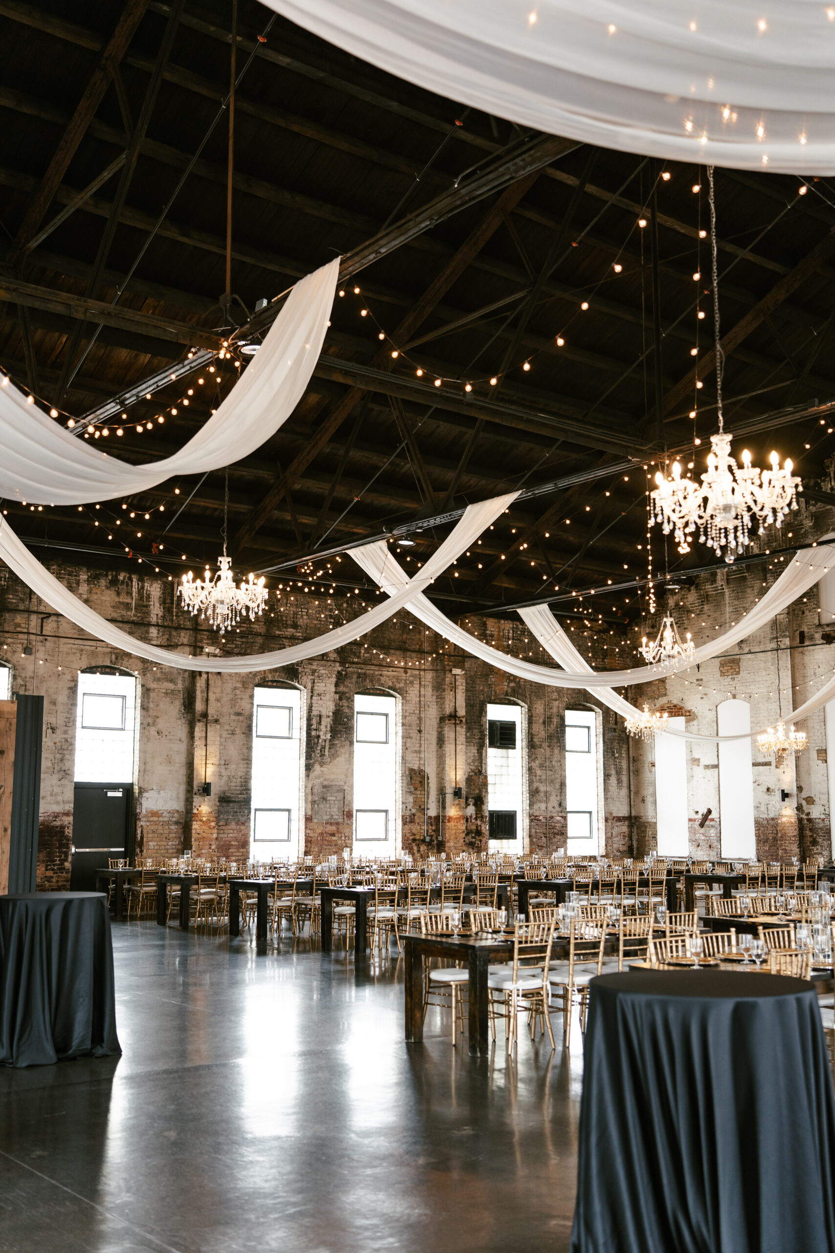 Wedding venue in Northern Minnesota with tall ceilings, white drapery, and lights