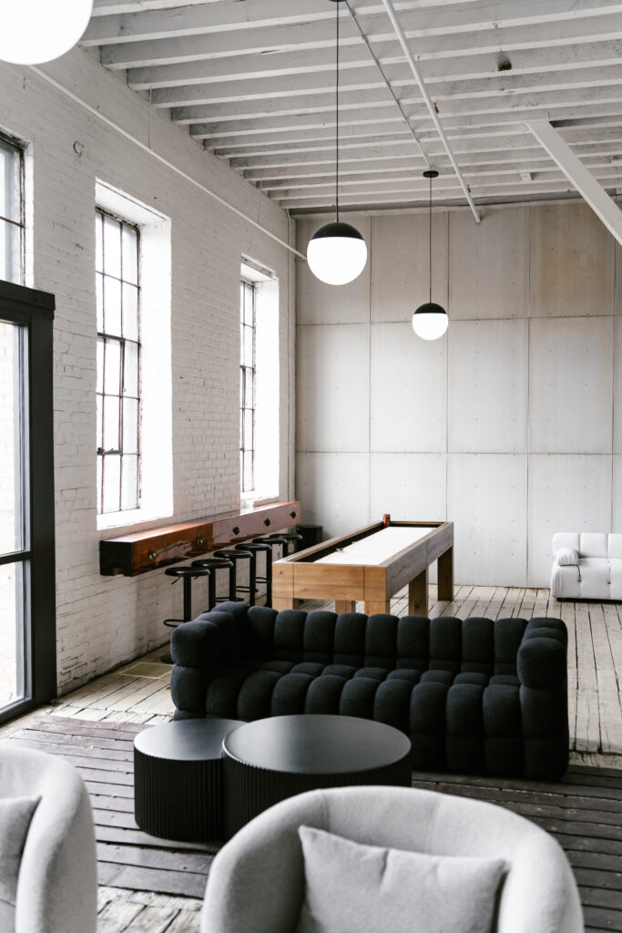 A black couch in a white room for the groomsmen to get ready in