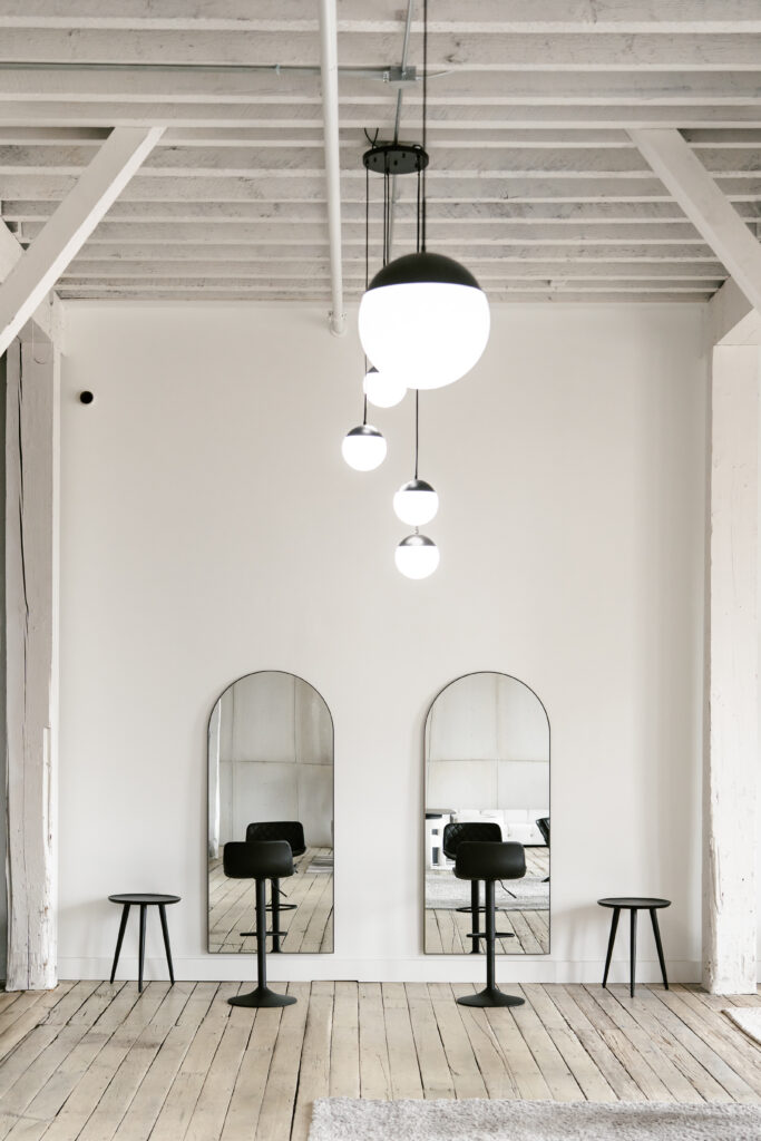 Getting ready space for a groom with black barstool chairs and large mirrors